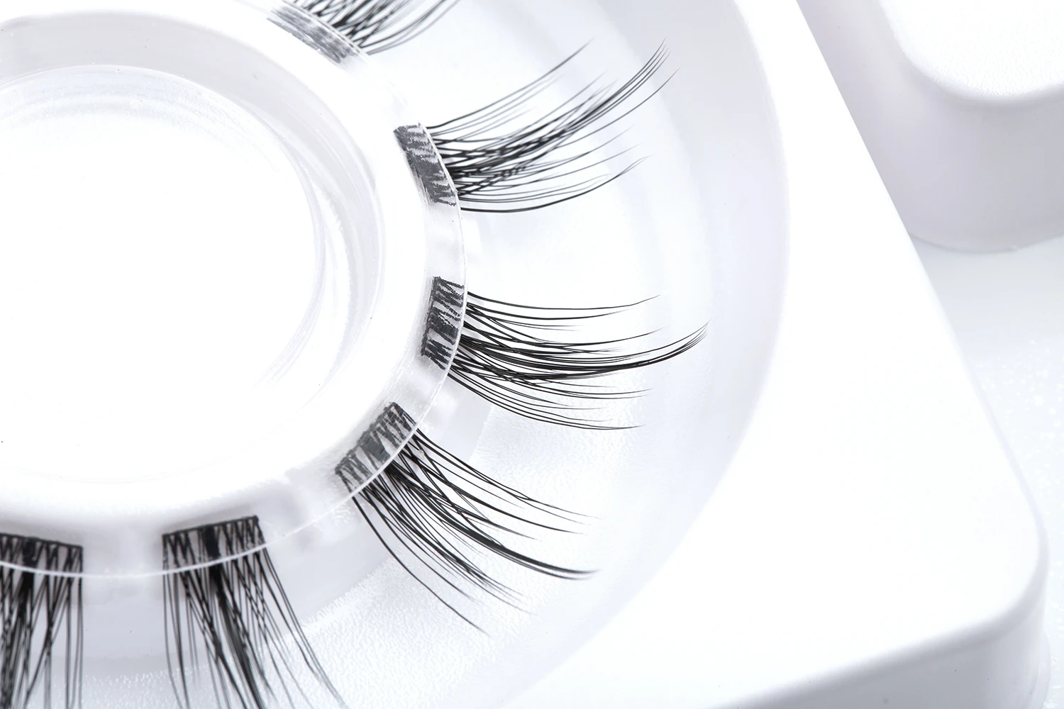 Supplied source photograph of natural sandwich DIY lash clusters on a clear carrier